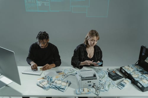 personas contando dolares en una mesa